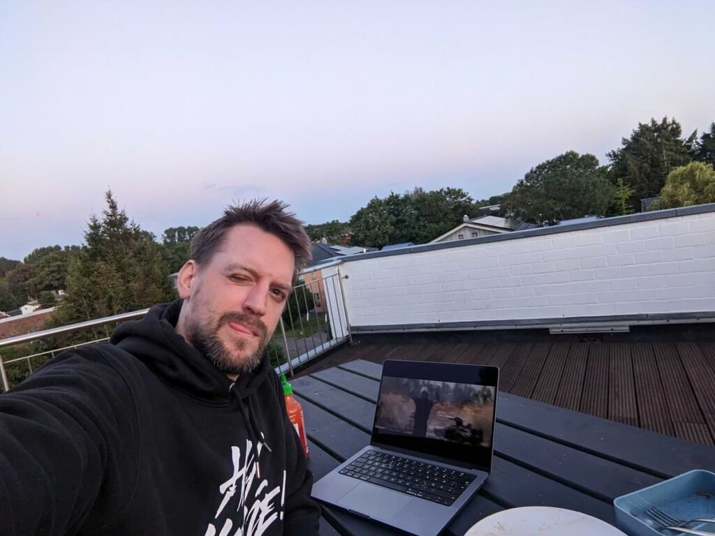 nico sitzt mit notebook auf dachterrasse von appmotion husum